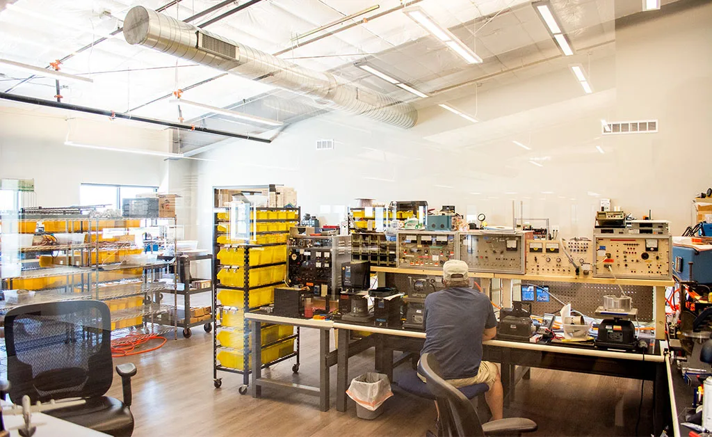 View of Avionics workshop, featuring a technician working at a bench with various avionics instruments.